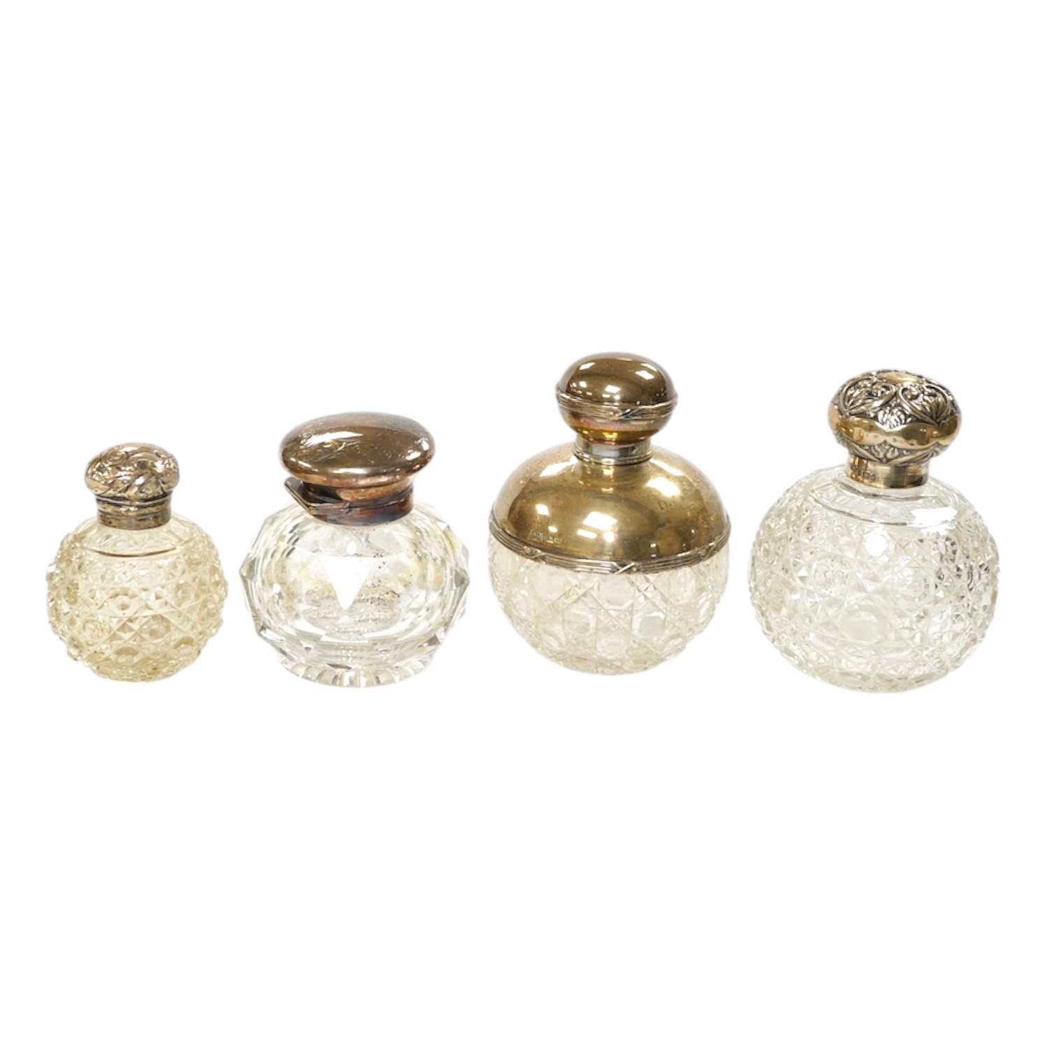 Four assorted mounted glass scent bottles, including three with silver mounts, tallest 11.9cm. Condition - poor